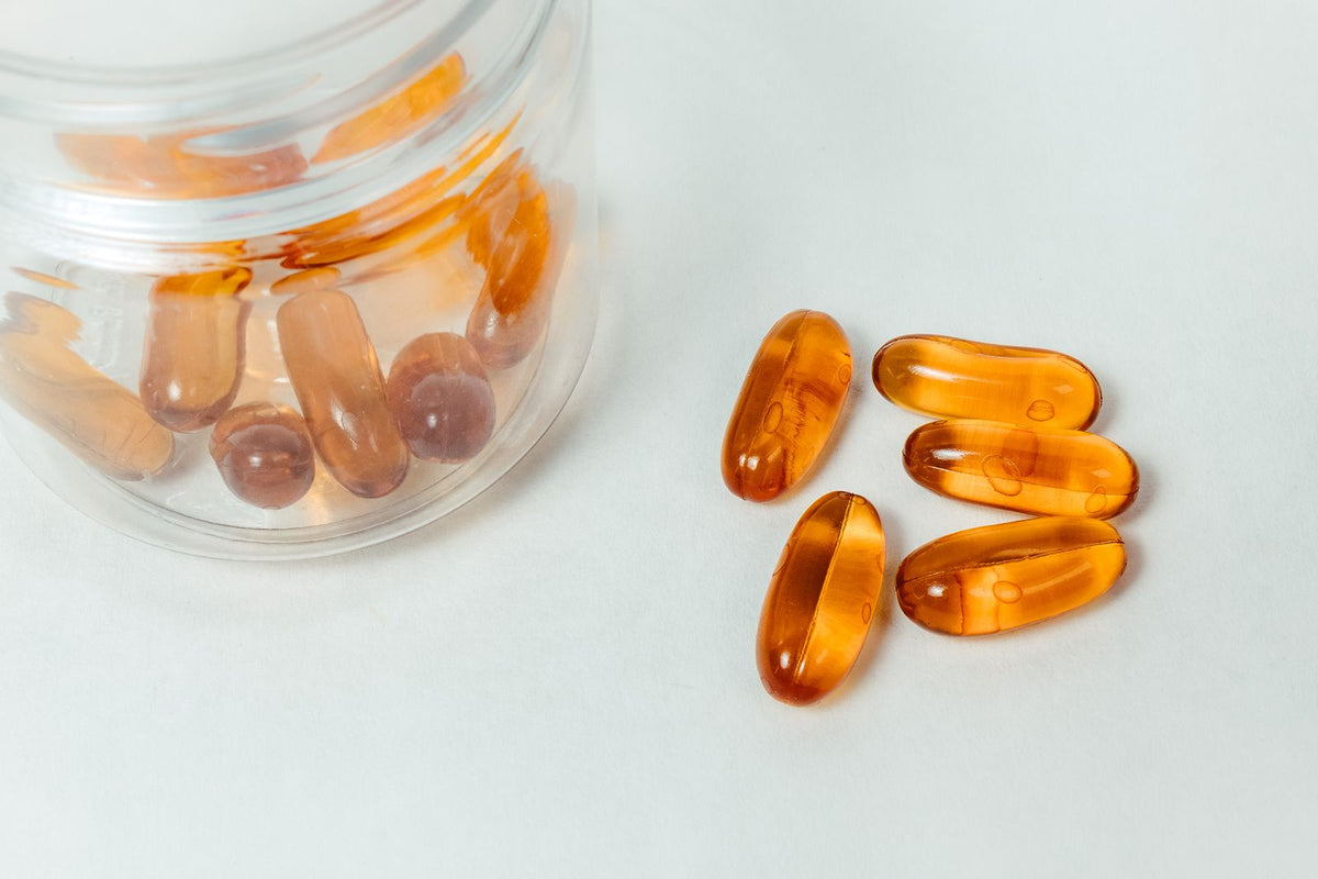 Gélules et capsules de complément alimentaire disposées sur une surface claire