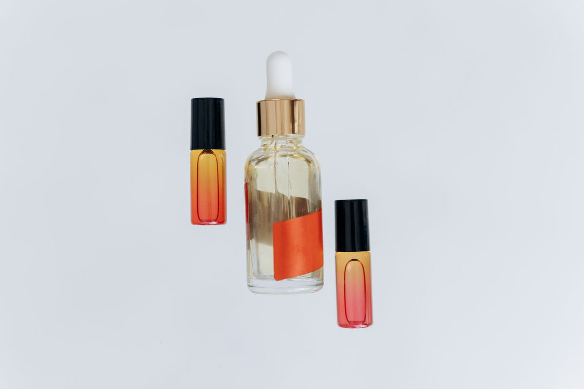 Flacon d'huile capillaire et compte-gouttes sur fond neutre