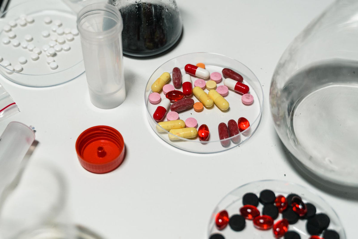 Gélules et capsules sur surface blanche évoquant un actif scientifique